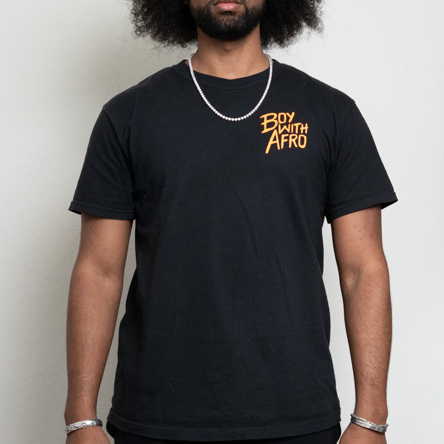 front view of a black t-shirt with the BoyWithAfro logo on the upper left chest