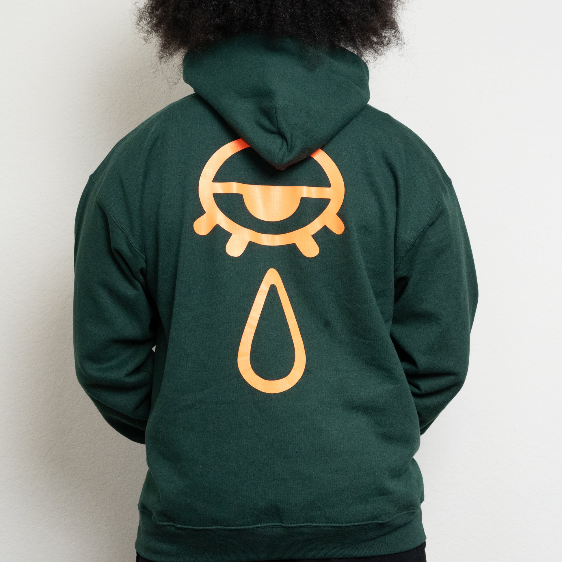 back-side of a deep forest green hoodie with an eye and teardrop in the center
