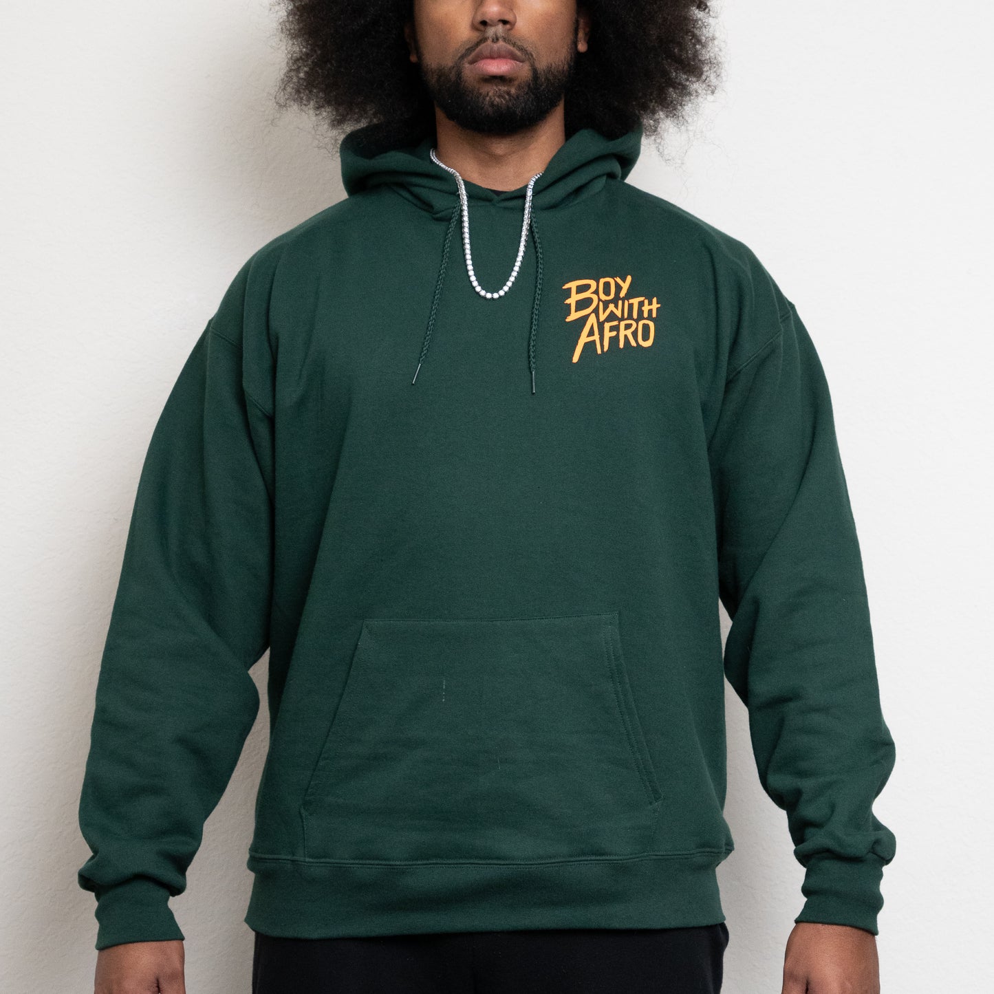front-side of a deep forest green hoodie with the BoyWithAfro logo on the upper left chest